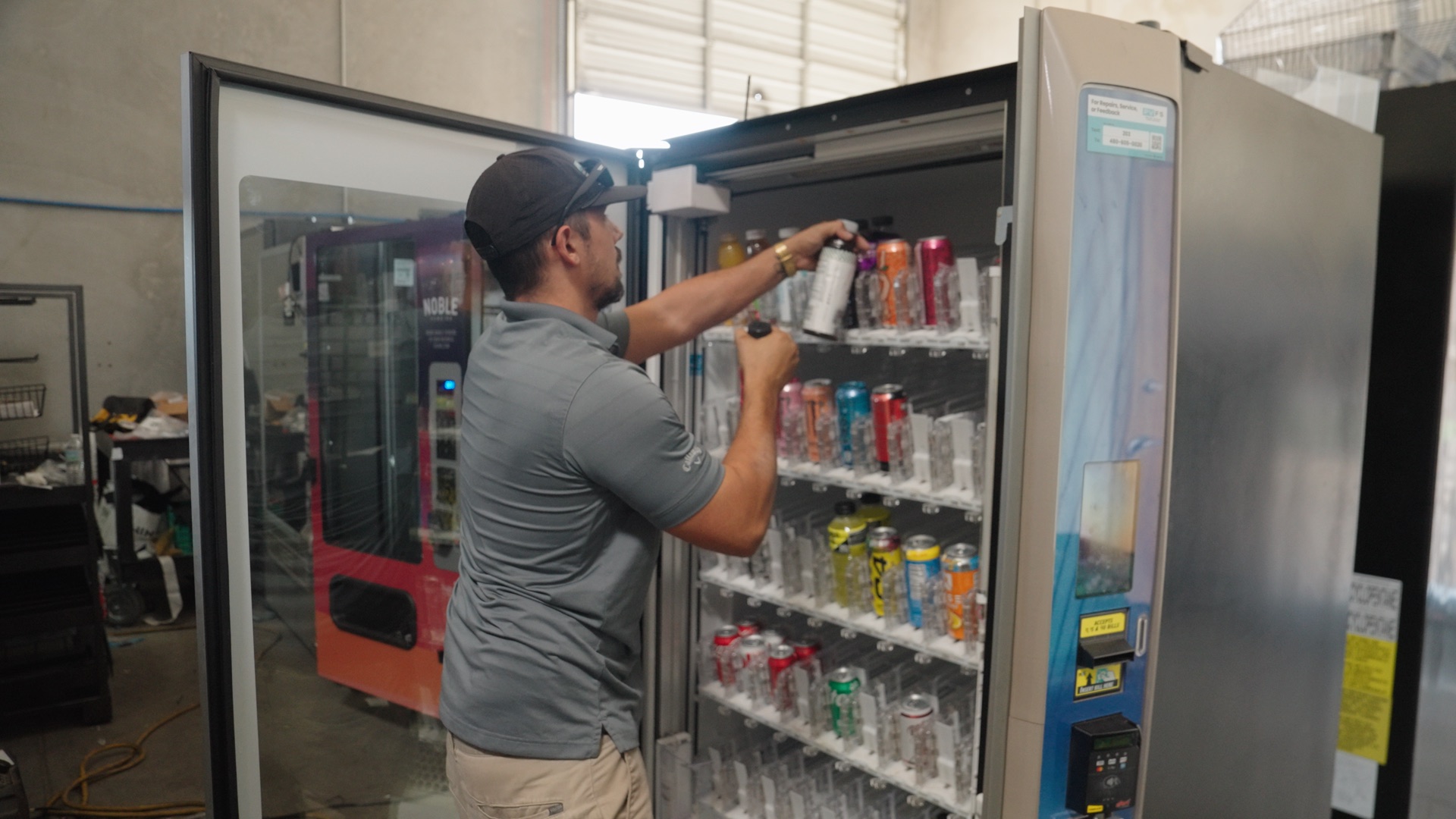 A route driver stocking a glass-front cooler with drinks